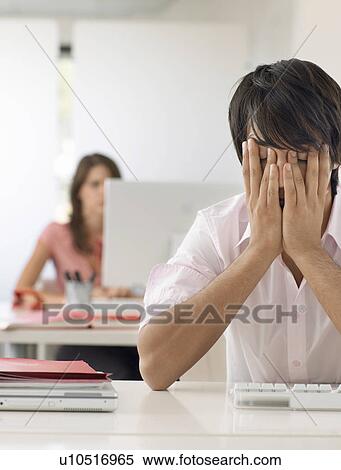 Business man at desk with head in hands View Large Photo Image Stock Photography - Business man at desk with head in hands. Fotosearch