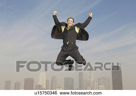 Business man pumping fists mid-air above city View Large Photo Image Stock Photograph - Business man pumping fists mid-air above city. Fotosearch