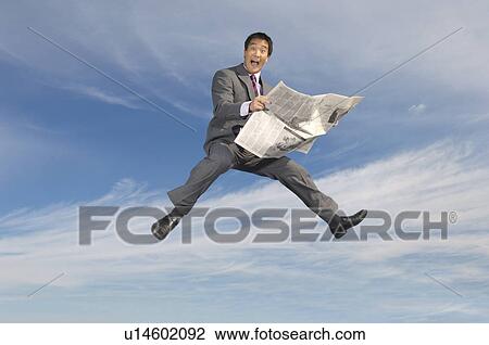 Business man reading newspaper mid-air outdoors View Large Photo Image Stock Image - Business man reading newspaper mid-air outdoors. Fotosearch