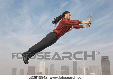 Business man reading newspaper mid-air above city View Large Photo Image Stock Image - Business man reading newspaper mid-air above city. Fotosearch