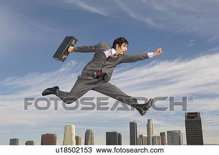 Business man running mid-air above city View Large Photo Image Stock Image - Business man running mid-air above city. Fotosearch