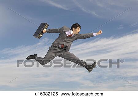 Business man running with briefcase mid-air outdoors View Large Photo Image Stock Photography - Business man running with briefcase mid-air outdoors. Fotosearch