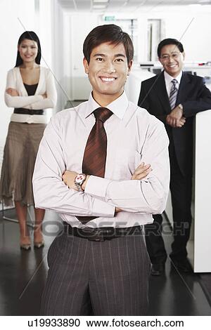 Business man standing in front of colleagues in office portrait View Large Photo Image Stock Image - Business man standing in front of colleagues in office portrait. Fotosearch