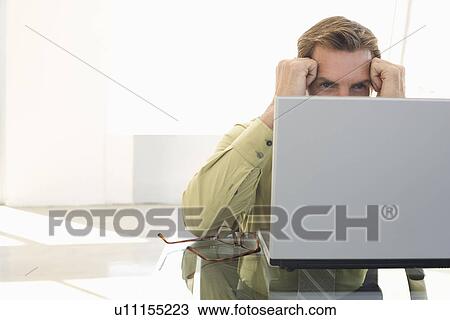 Stock Image - Business man using laptop in office. Fotosearch