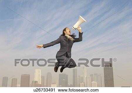 Business woman shouting in bullhorn mid-air above city View Large Photo Image Stock Image - Business woman shouting in bullhorn mid-air above city. Fotosearch