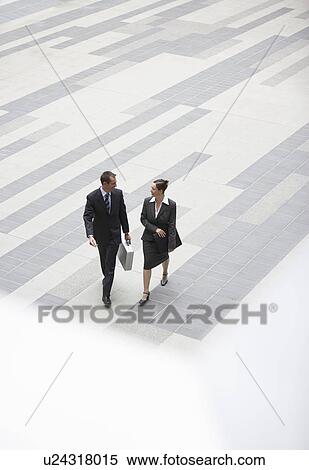 Businessman and businesswoman walking across outdoor plaza elevated view View Large Photo Image Stock Photography - Businessman and businesswoman walking across outdoor plaza elevated view. Fotosearch