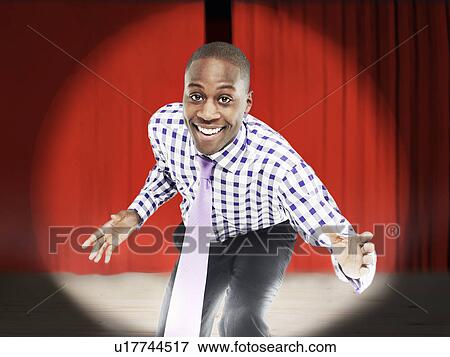 Stock Photo - Businessman bending forward in front of red curtains digital composite. Fotosearch