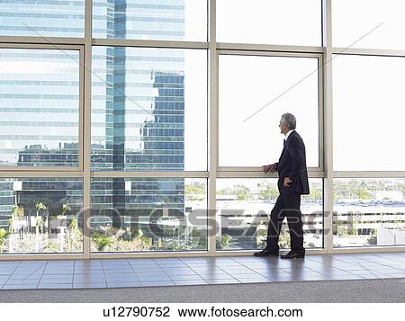 Businessman looking out of office window View Large Photo Image Stock Image - Businessman looking out of office window. Fotosearch