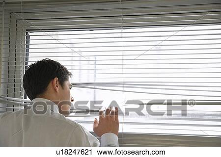 Businessman Looking out office Window through Venetian blinds close up view from behind View Large Photo Image Stock Image - Businessman Looking out office Window through Venetian blinds close up view from behind. Fotosearch