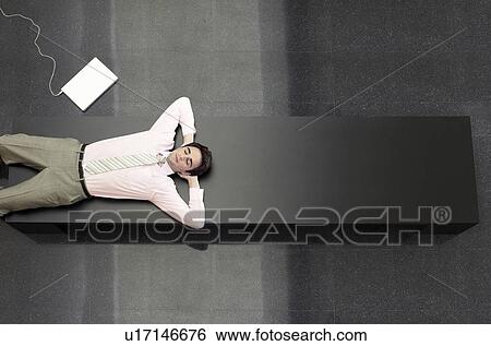 Stock Photograph - Businessman Lying down on Bench view from above. Fotosearch