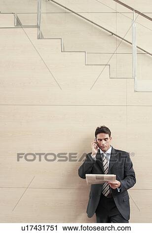 Businessman on cell phone at bottom of stairway half length View Large Photo Image Stock Image - Businessman on cell phone at bottom of stairway half length. Fotosearch