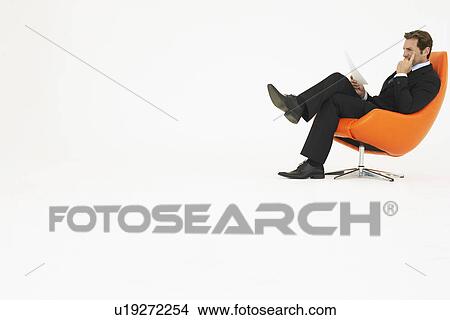 Businessman reading in chair on white background View Large Photo Image Picture - Businessman reading in chair on white background. Fotosearch