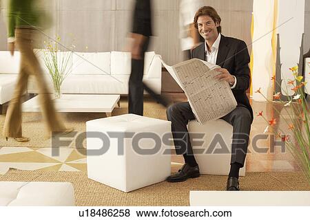Businessman reading newspaper in lobby portrait View Large Photo Image Stock Photo - Businessman reading newspaper in lobby portrait. Fotosearch