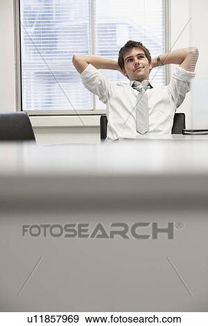 Businessman reclining in office chair looking at ceiling daydreaming View Large Photo Image Stock Photo - Businessman reclining in office chair looking at ceiling daydreaming. Fotosearch