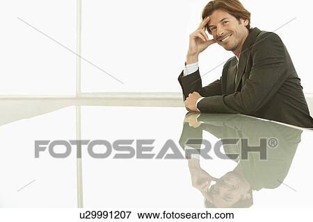 Businessman sitting at conference table portrait View Large Photo Image Stock Photo - Businessman sitting at conference table portrait. Fotosearch