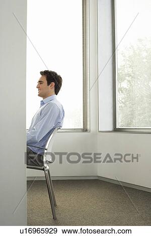 Businessman Sitting On Chair In Office Side View Half Length Stock Businessman Sitting On Chair In Office