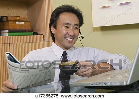 Businessman talking on headset Using Laptop and Reading Newspaper View Large Photo Image Stock Photography - Businessman talking on headset Using Laptop and Reading Newspaper. Fotosearch