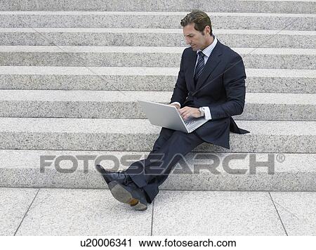 Businessman using laptop on steps View Large Photo Image Stock Image - Businessman using laptop on steps. Fotosearch