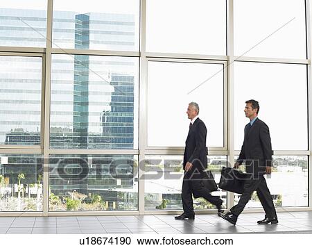 Businessman walking by office window View Large Photo Image Stock Image - Businessman walking by office window. Fotosearch