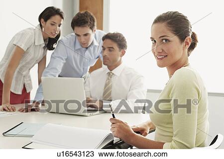 Stock Image - Businessmen and women in meeting. Fotosearch