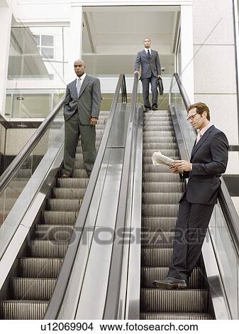 Businessmen on escalators View Large Photo Image Picture - Businessmen on escalators. Fotosearch