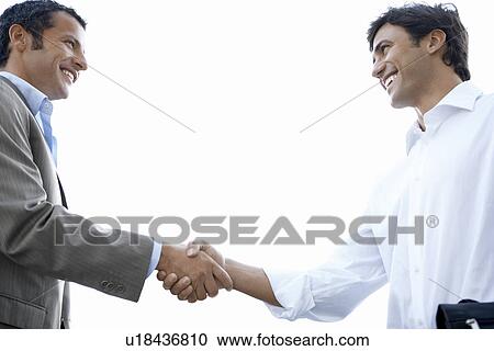 Businessmen shaking hands side view View Large Photo Image Stock Image - Businessmen shaking hands side view. Fotosearch