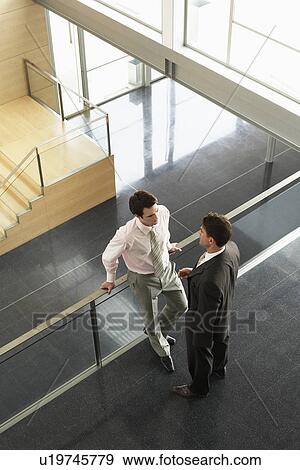 Businessmen talking on Mezzanine elevated view View Large Photo Image Stock Photo - Businessmen talking on Mezzanine elevated view. Fotosearch
