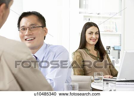 Stock Image - Businesspeople working in office. Fotosearch