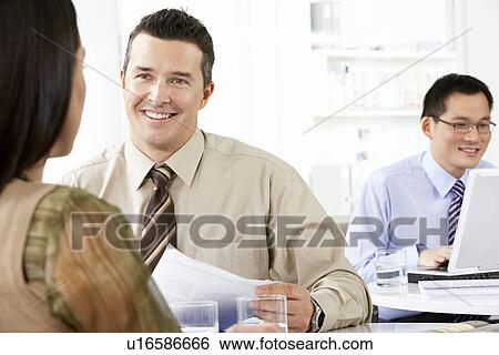 Stock Photograph - Businesspeople working in office. Fotosearch