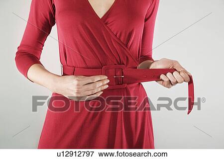 Businesswoman adjusting belt mid section View Large Photo Image Stock Photo - Businesswoman adjusting belt mid section. Fotosearch