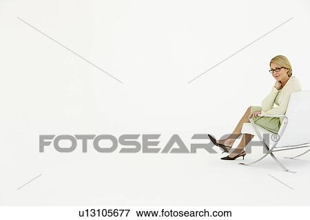 Stock Photo - Businesswoman sitting in chair on white background portrait. Fotosearch