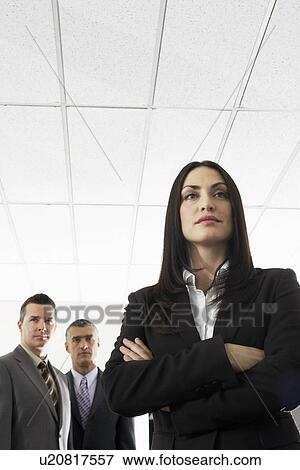Stock Photo - Businesswoman with two businessmen portrait low angle view. Fotosearch
