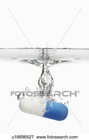 Capsule pill sinking in water close-up View Large Photo Image Stock Photo - Capsule pill sinking in water close-up. Fotosearch