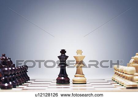 Stock Photograph - Chess game two kings in centre of board other pieces lined up. Fotosearch