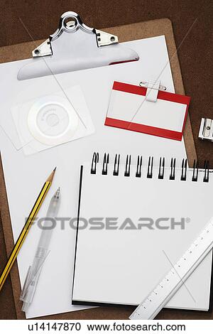 Stock Image - Clipboard notepad pencil and other office equipment arranged in studio. Fotosearch