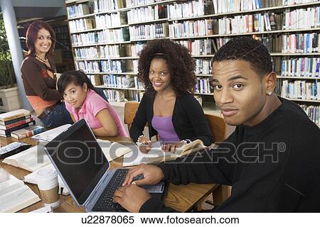 Stock Photography - College students studying together in library. Fotosearch