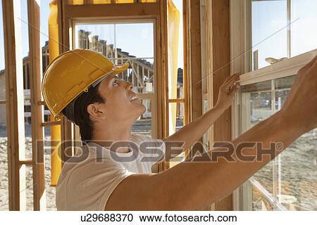 Stock Image - Construction Worker Building a House. Fotosearch