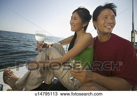 Couple dinking white wine on boat View Large Photo Image Stock Image - Couple dinking white wine on boat. Fotosearch