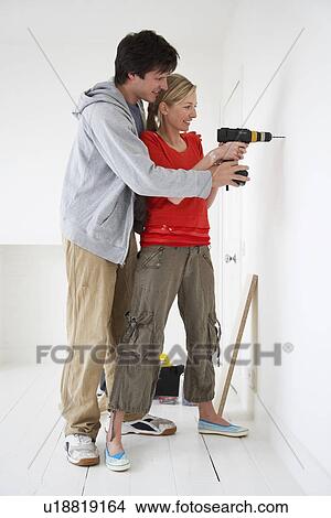 Couple drilling inside their new home View Large Photo Image Picture - Couple drilling inside their new home. Fotosearch