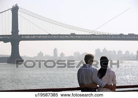 Stock Photography - Couple embracing by river. Fotosearch