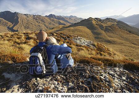 Couple embracing looking at hills back view View Large Photo Image Stock Photograph - Couple embracing looking at hills back view. Fotosearch