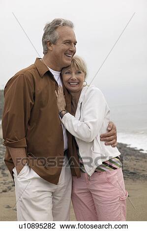 Couple embracing on beach (portrait) View Large Photo Image Stock Image - Couple embracing on beach (portrait). Fotosearch