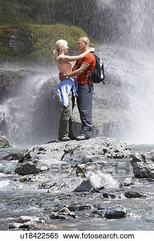 Couple embracing under spray of waterfall View Large Photo Image Stock Photography - Couple embracing under spray of waterfall. Fotosearch