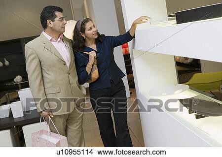 Couple Examining Glass Bowl in furniture shop View Large Photo Image Picture - Couple Examining Glass Bowl in furniture shop. Fotosearch