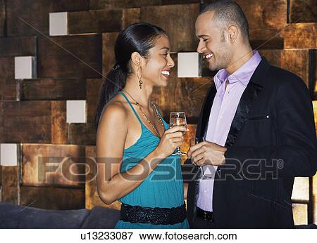Stock Photo - Couple flirting standing face to face in bar. Fotosearch