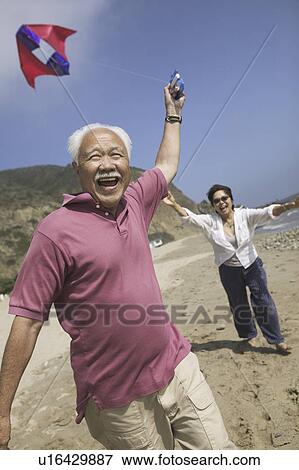 Couple flying kite on Beach View Large Photo Image Stock Photo - Couple flying kite on Beach. Fotosearch