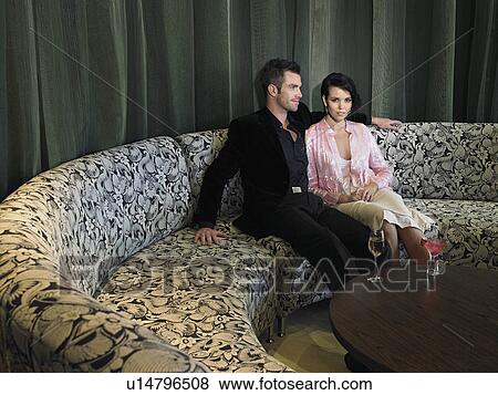 Couple having wine in hotel lobby View Large Photo Image Stock Photo - Couple having wine in hotel lobby. Fotosearch