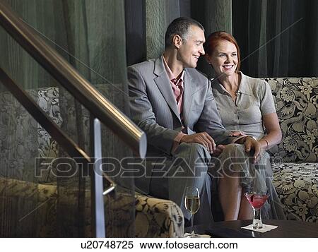 Couple having wine in hotel lobby View Large Photo Image Stock Photography - Couple having wine in hotel lobby. Fotosearch