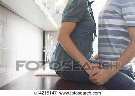 Couple holding hands in kitchen mid section View Large Photo Image Stock Photo - Couple holding hands in kitchen mid section. Fotosearch