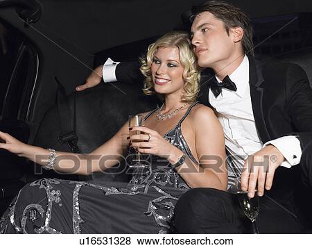 Couple in back of car drinking champagne looking away View Large Photo Image Stock Photo - Couple in back of car drinking champagne looking away. Fotosearch